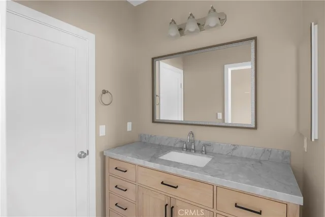 a bathroom with a granite countertop sink and a mirror