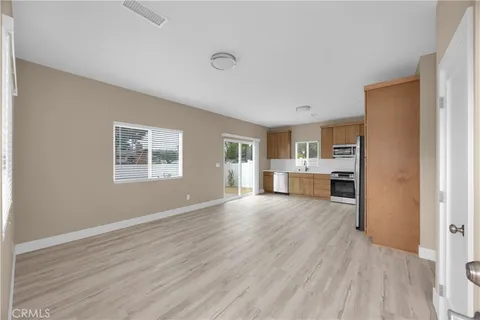 a view of a kitchen with wooden floor and windows