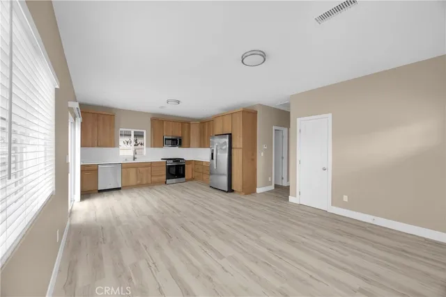 a view of a kitchen with a sink dishwasher cabinets and a large window