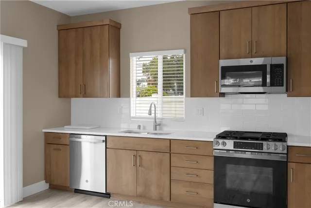 a kitchen with white cabinets sink and stainless steel appliances
