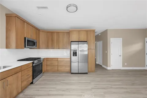 a kitchen with granite countertop a refrigerator stove top oven and sink
