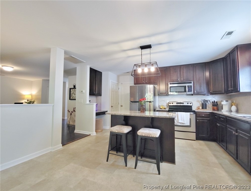 30 Bicentennial Way Cameron, NC 28326 - Photo 11 of 42 a kitchen with kitchen island granite countertop a sink and a refrigerator