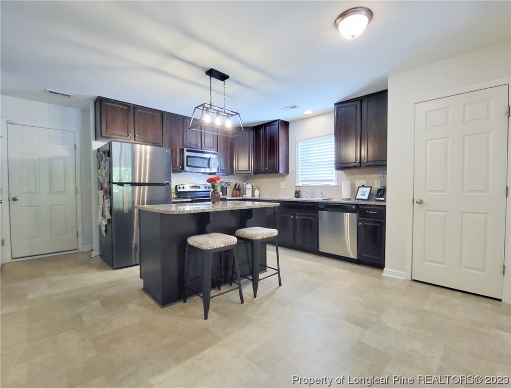 30 Bicentennial Way Cameron, NC 28326 - Photo 12 of 42 a kitchen with kitchen island a sink stainless steel appliances and cabinets