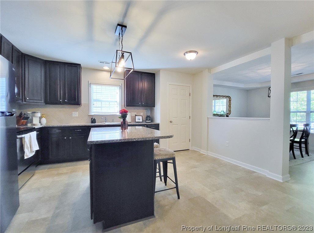 30 Bicentennial Way Cameron, NC 28326 - Photo 14 of 42 a kitchen with kitchen island granite countertop a sink cabinets and window