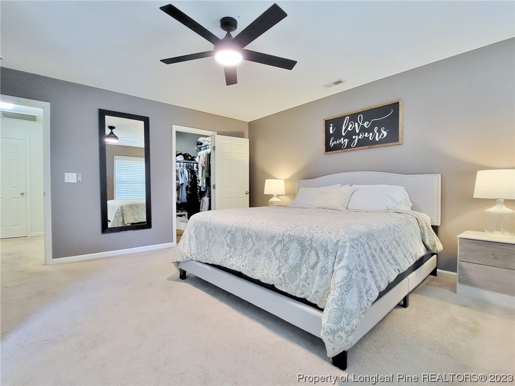 30 Bicentennial Way Cameron, NC 28326 - Photo 20 of 42 a spacious bedroom with a large bed and a chandelier