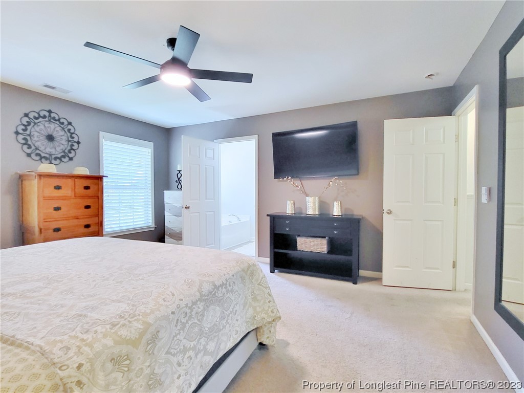 30 Bicentennial Way Cameron, NC 28326 - Photo 21 of 42 a bedroom with a bed and a flat screen tv