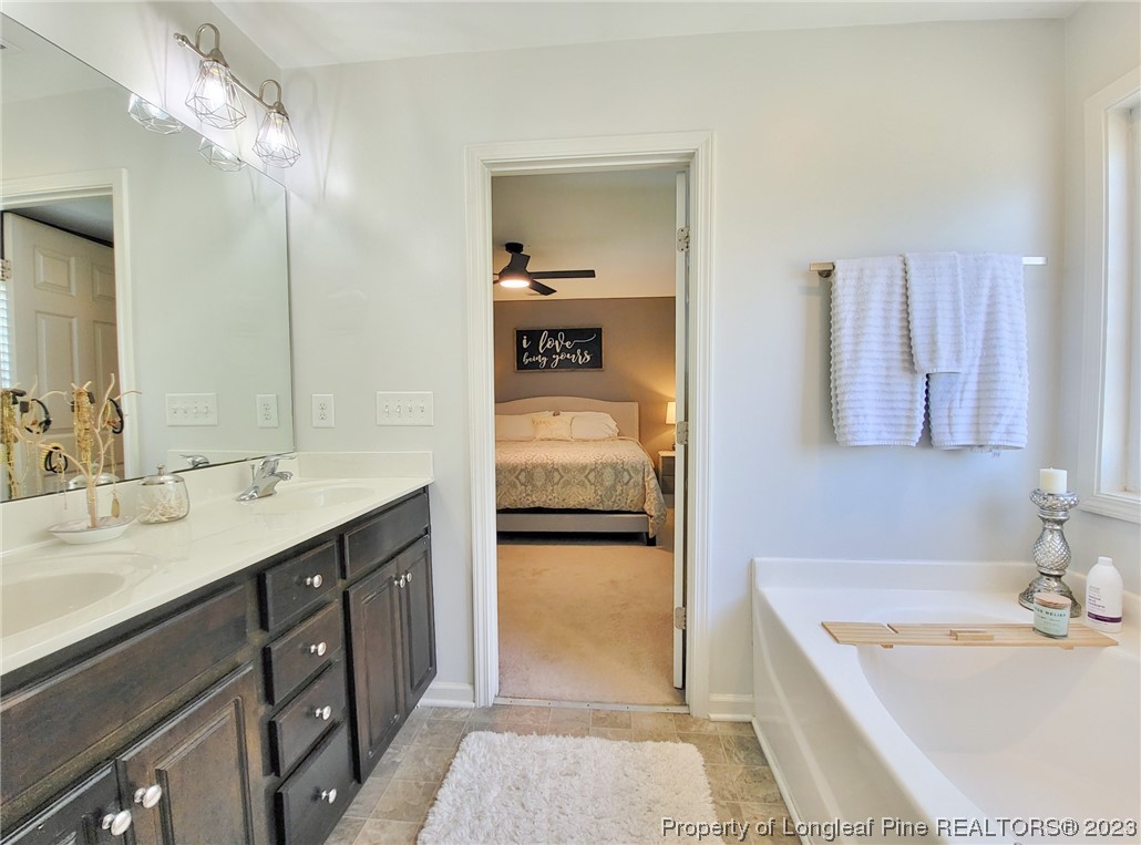 30 Bicentennial Way Cameron, NC 28326 - Photo 22 of 42 a en suite bathroom with a tub double sink and mirror