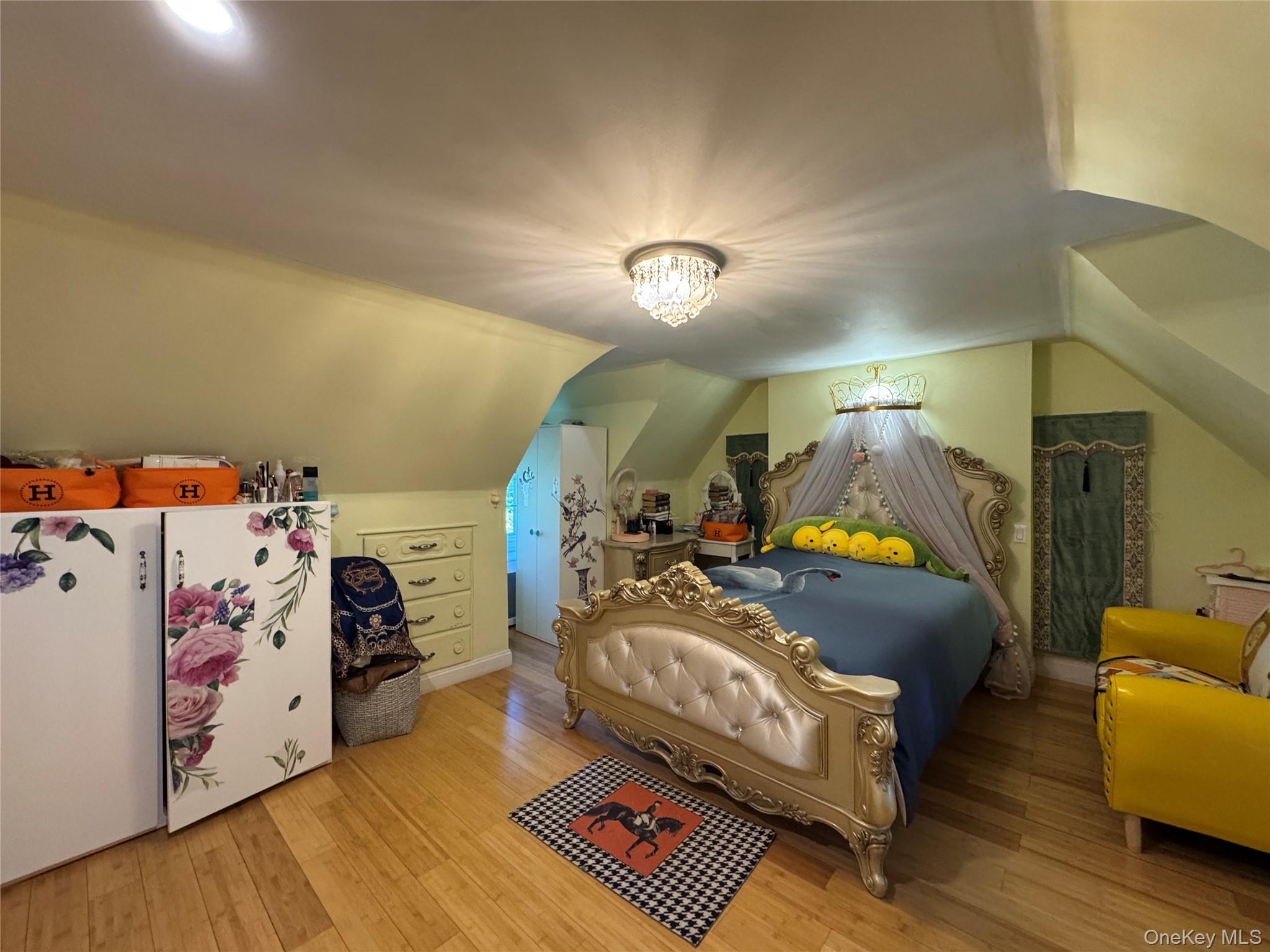 16 Ascot Ridge Great Neck, NY 11021 - Photo 16 of 23 Bedroom featuring light wood-type flooring, lofted ceiling, and a chandelier
