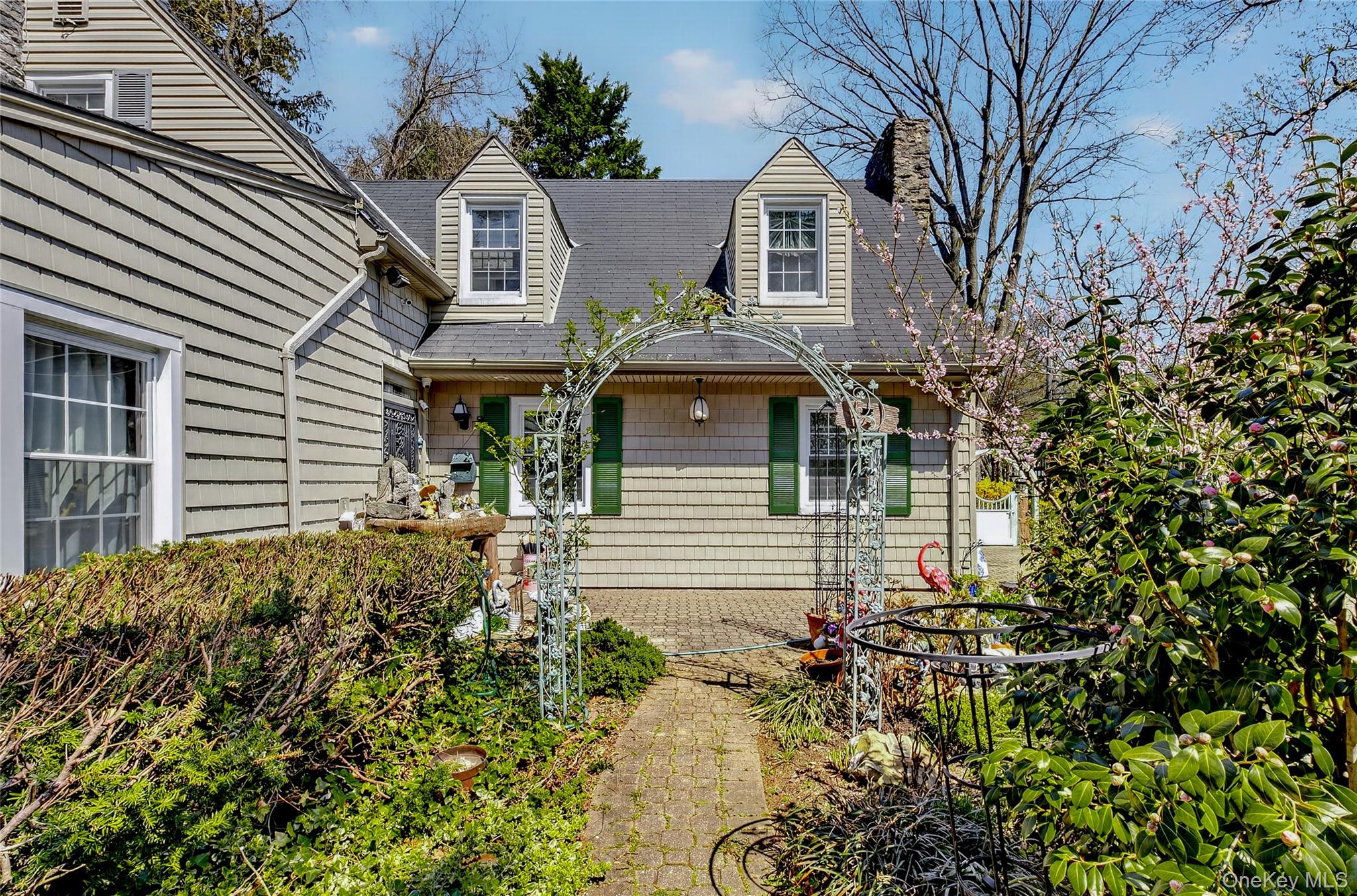 16 Ascot Ridge Great Neck, NY 11021 - Photo 24 of 33 front view of a house with a garden