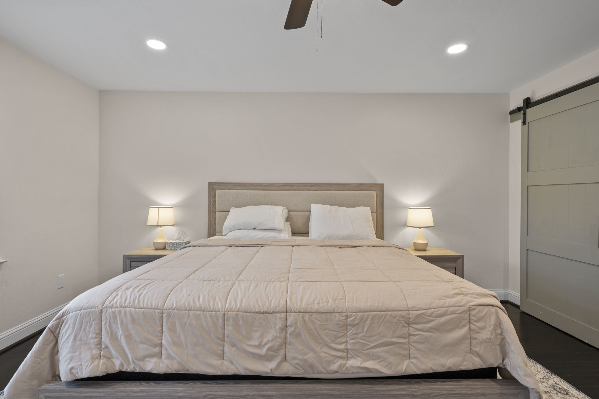 2402 Chimney Rock Road Houston, TX 77057 - Photo 15 of 36 Cozy primary suite with neutral finishes, stylish barn door closet, and soft lighting for a relaxing retreat.