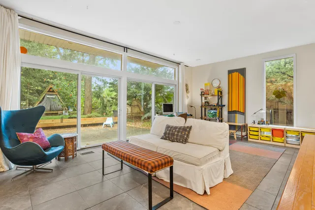 a living room with furniture and floor to ceiling windows