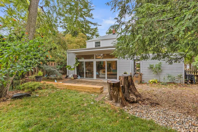 a view of a chair and table in backyard of the house