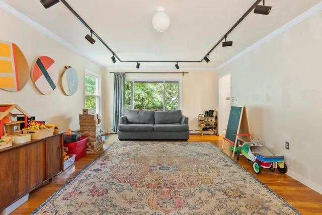 a living room with furniture toys and a large window