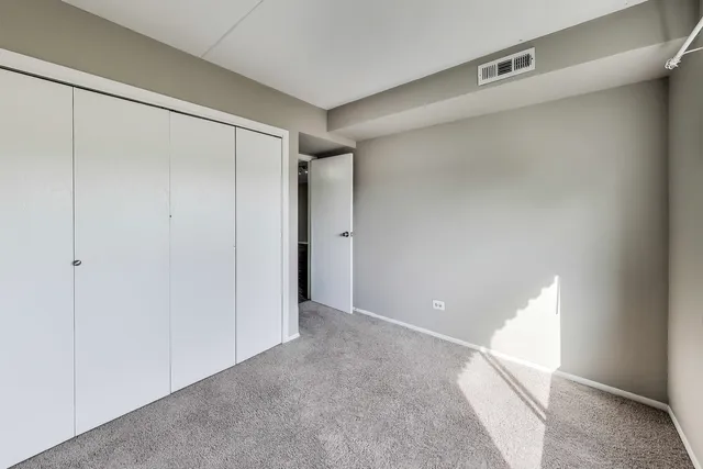 an empty room with windows and ceiling fan