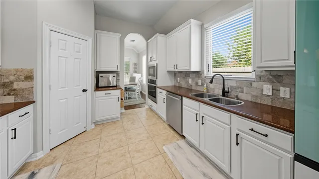 a large white kitchen with cabinets