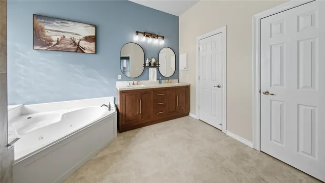 a spacious bathroom with a tub sink and mirror