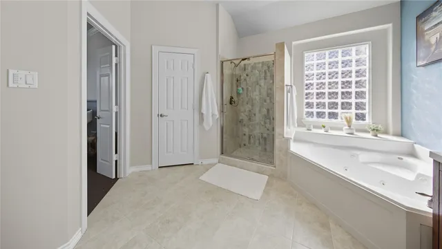 a spacious bathroom with a tub shower and sink