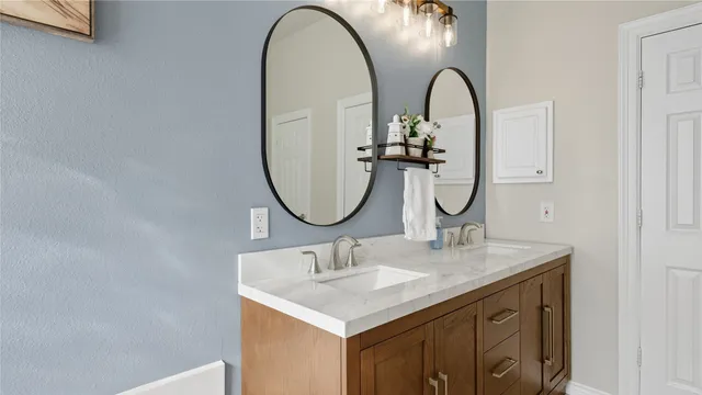 a bathroom with a granite countertop sink a large mirror and vanity