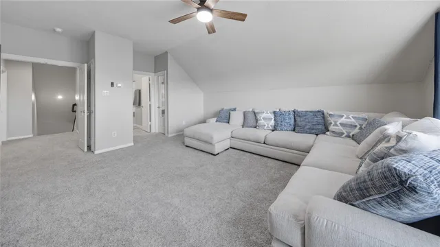 a living room with furniture and a ceiling fan