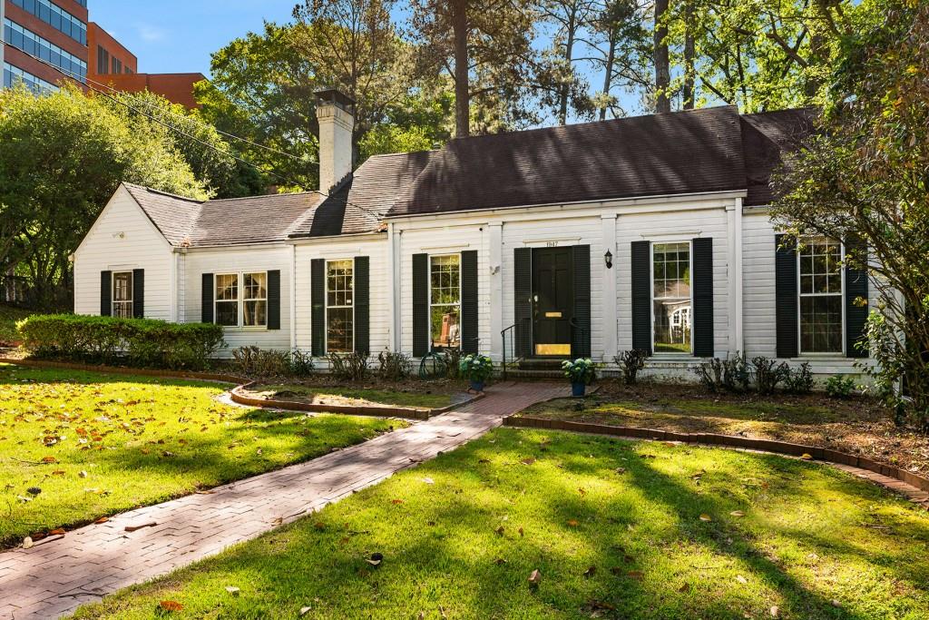 a view of a house with backyard and sitting area
