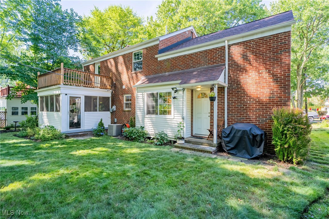 3684 Fenley Road Cleveland Heights, OH 44121 - Photo 34 of 38 Back of property with a balcony, a shingled roof, brick siding, a yard, and a sunroom
