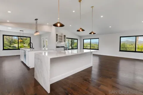 a kitchen with kitchen island a sink appliances and a large window