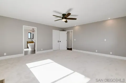 a view of empty room with floor to ceiling window and wooden floor