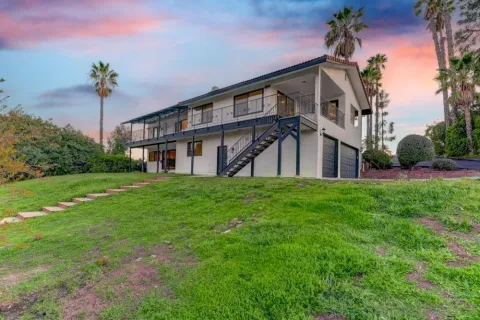 a view of a patio with table and chairs next to a yard