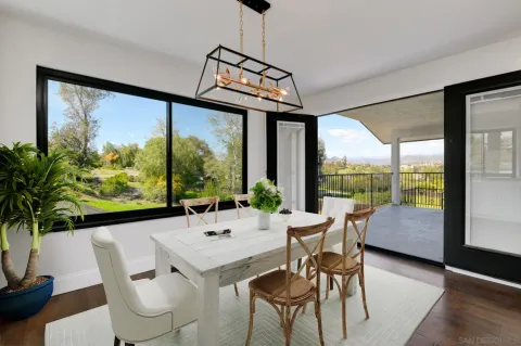 a view of a dining room with furniture large windows and wooden floor