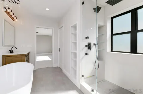 a en suite bathroom with a tub shower and mirror