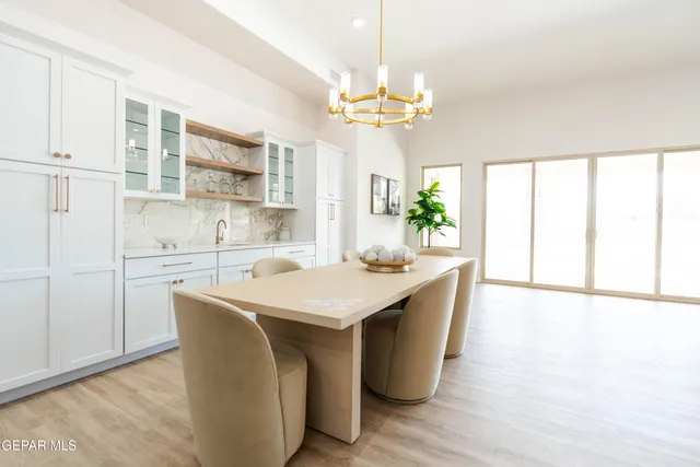 a kitchen with stainless steel appliances a table and chairs