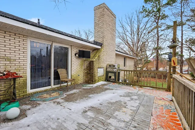a view of garage with a table and chairs under an umbrella
