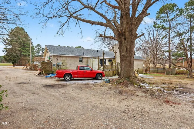 a view of a garage with a table and chairs under an umbrella