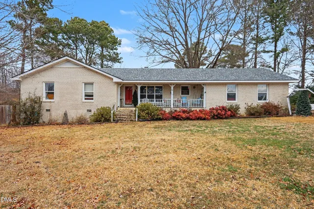 a front view of house with yard and trees around