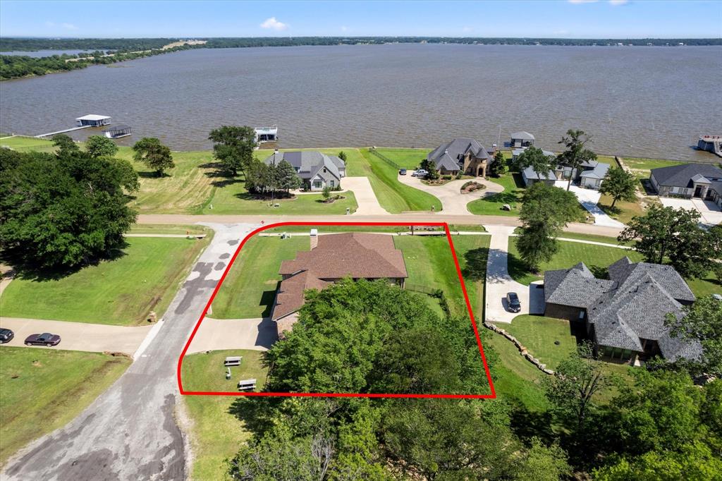 an aerial view of a house with a yard and lake view