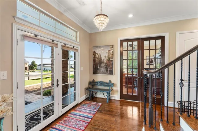 a view of a hallway with wooden floor and windows