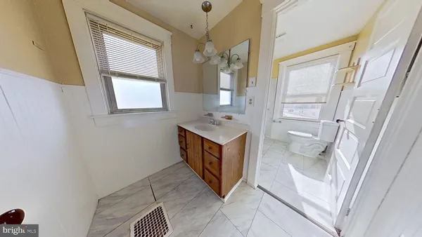 a spacious bathroom with a vanity mirror and a sink