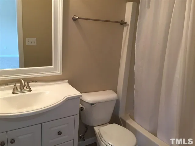 a white toilet sitting next to a bathroom sink and a shower