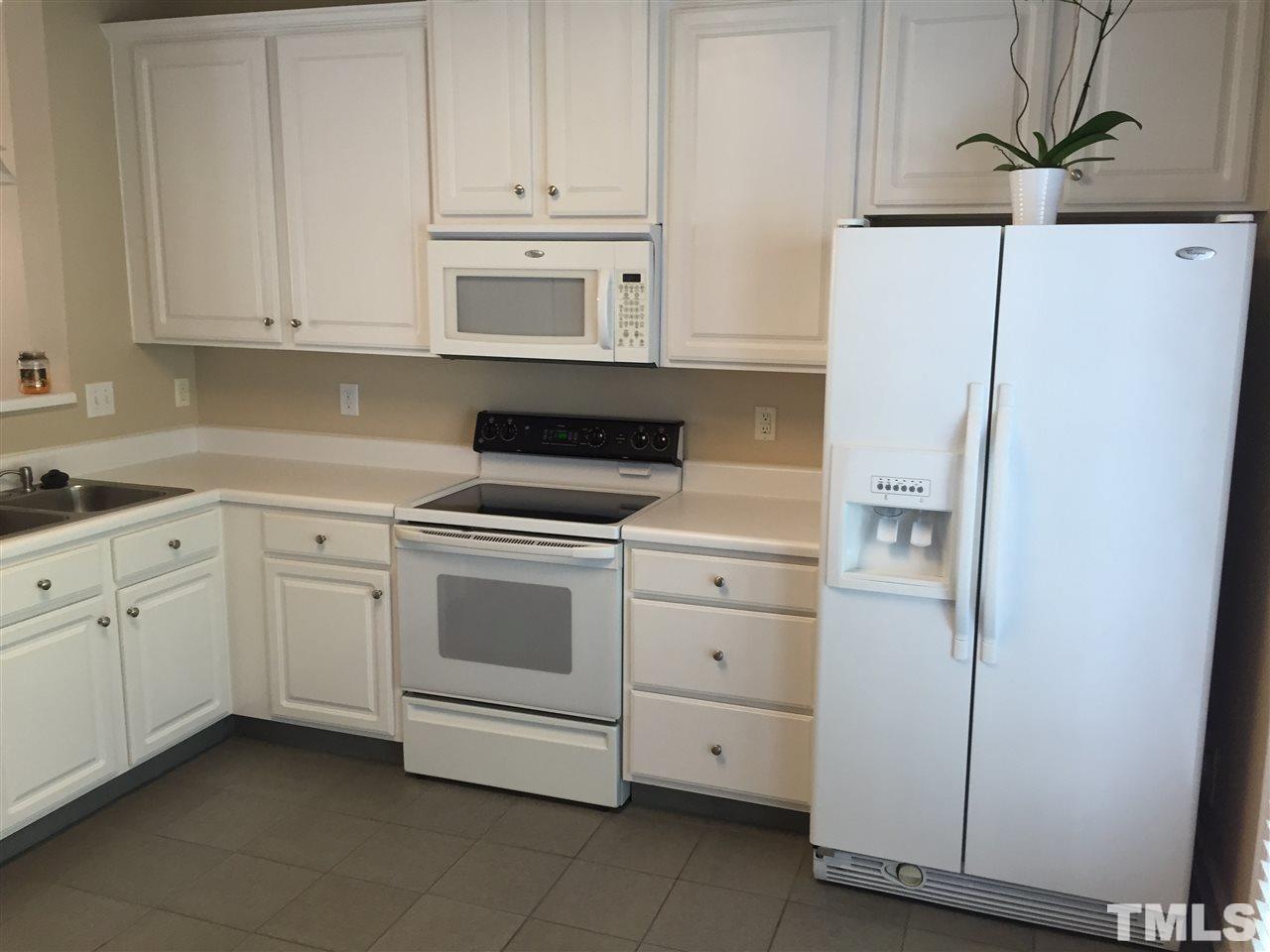 8605 London Park Court Raleigh, NC 27615 - Photo 7 of 18 a kitchen with white cabinets and white appliances