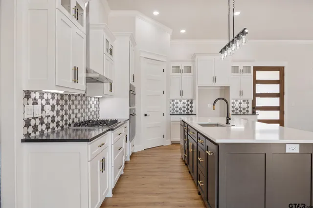 a kitchen with white cabinets and sink