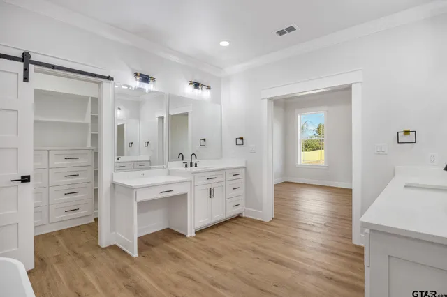 a large bathroom with a double vanity sink mirror and bathtub