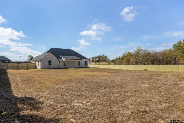 a view of a small house with backyard