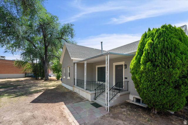 327 35th Street Ogden, UT 84401 - Photo 28 of 31 Exterior featuring a covered porch with white columns and black railings, a gray facade, and a dark entry door