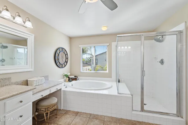 a bathroom with a granite countertop tub a sink and a mirror