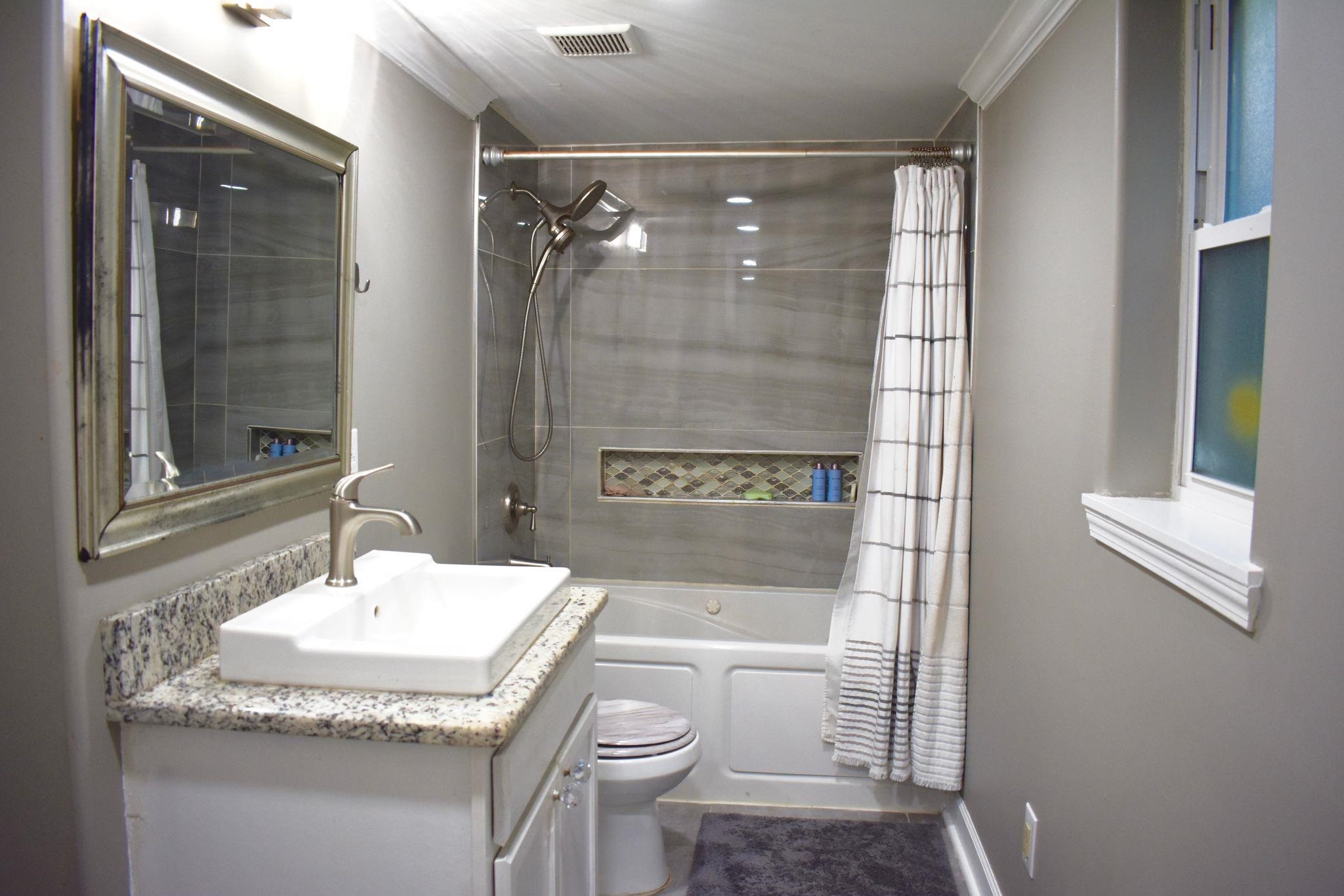 712 Sevier Street Memphis, TN 38122 - Photo 10 of 13 a bathroom with a granite countertop sink toilet and shower