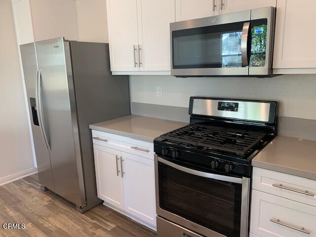 312 Dominguez Street Camarillo, CA 93010 - Photo 7 of 25 a kitchen with stainless steel appliances kitchen island a stove and a microwave