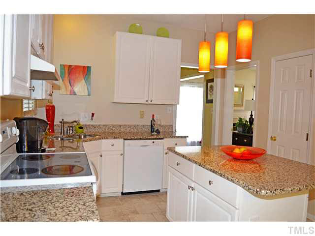7617 Overland Trail Raleigh, NC 27615 - Photo 16 of 25 a kitchen with stainless steel appliances granite countertop a sink dishwasher and cabinets with wooden floor