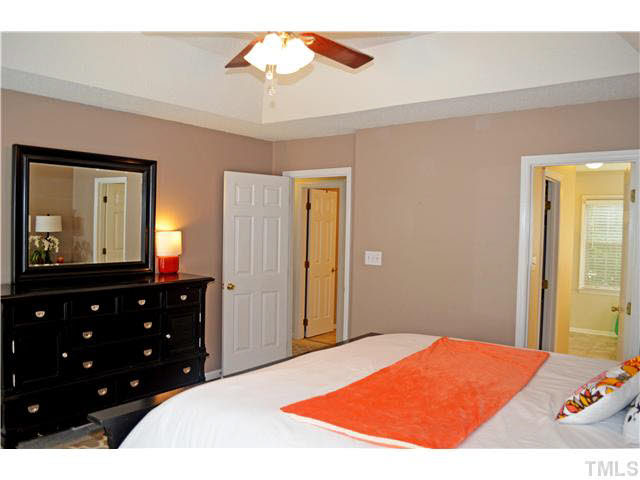7617 Overland Trail Raleigh, NC 27615 - Photo 23 of 25 a bedroom with a bed and a mirror on dresser