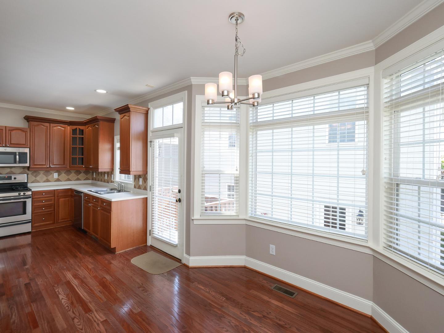 1155 Harp Street Raleigh, NC 27604 - Photo 13 of 33 a kitchen with stainless steel appliances granite countertop a refrigerator a sink dishwasher a stove and white cabinets with wooden floor