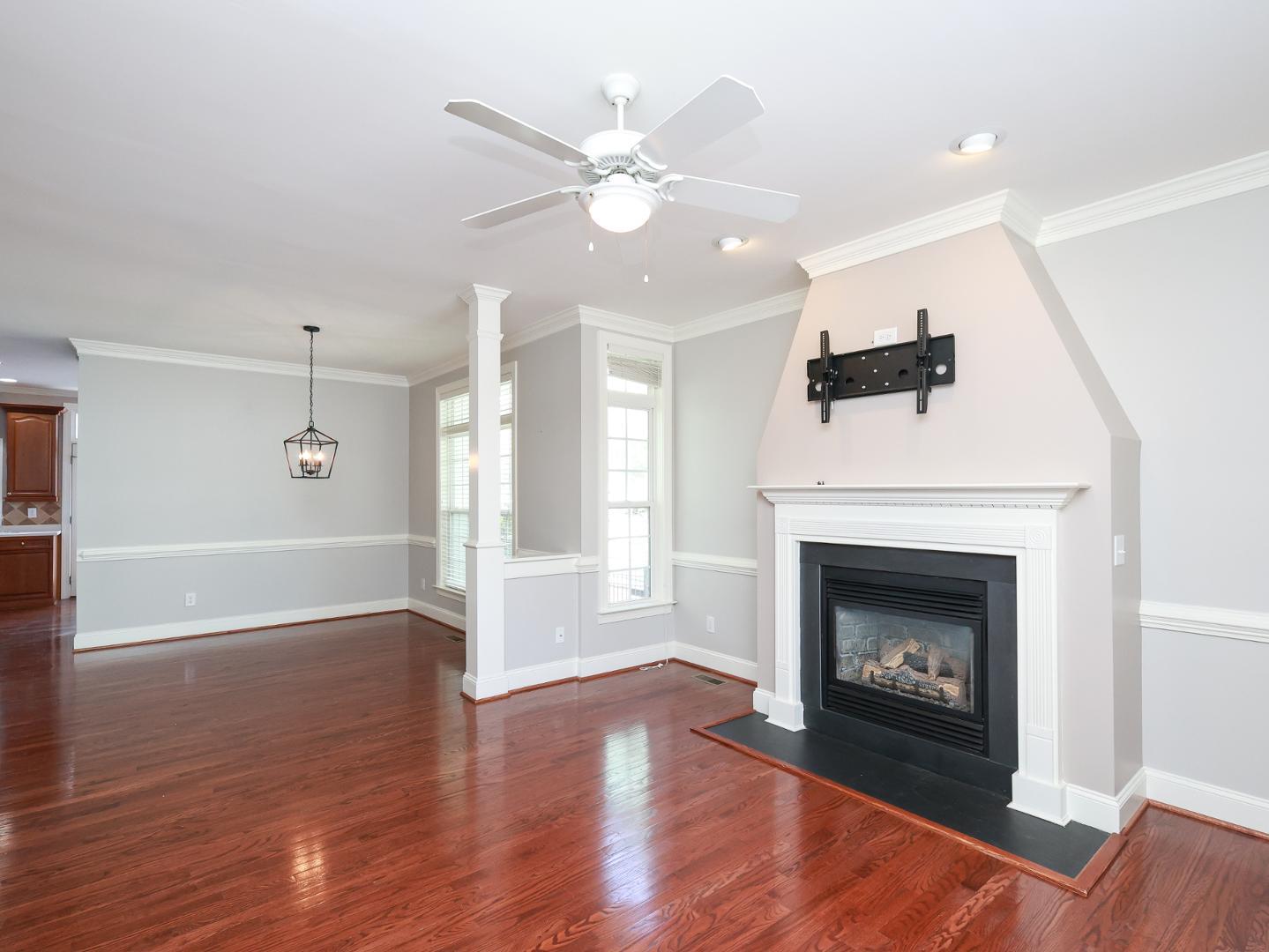 1155 Harp Street Raleigh, NC 27604 - Photo 6 of 33 a view of an empty room with wooden floor fireplace and a window